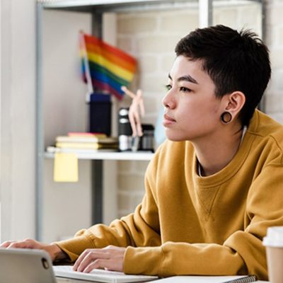 An individual staring at a computer off camera.