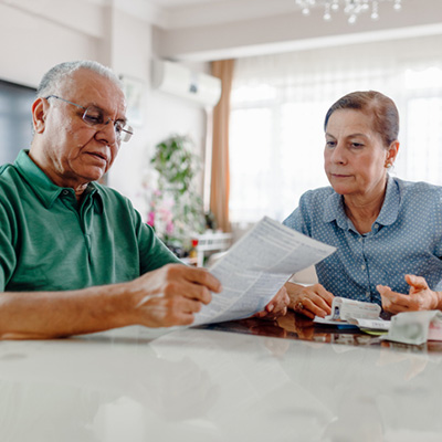 Senior couple at home with many bills