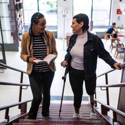 Two people walking up the stairs in a school setting