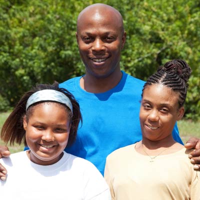 A photo of a father with his two daughters.